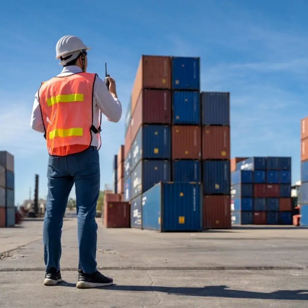Site supervisor in high-visibility gear inspecting a container yard