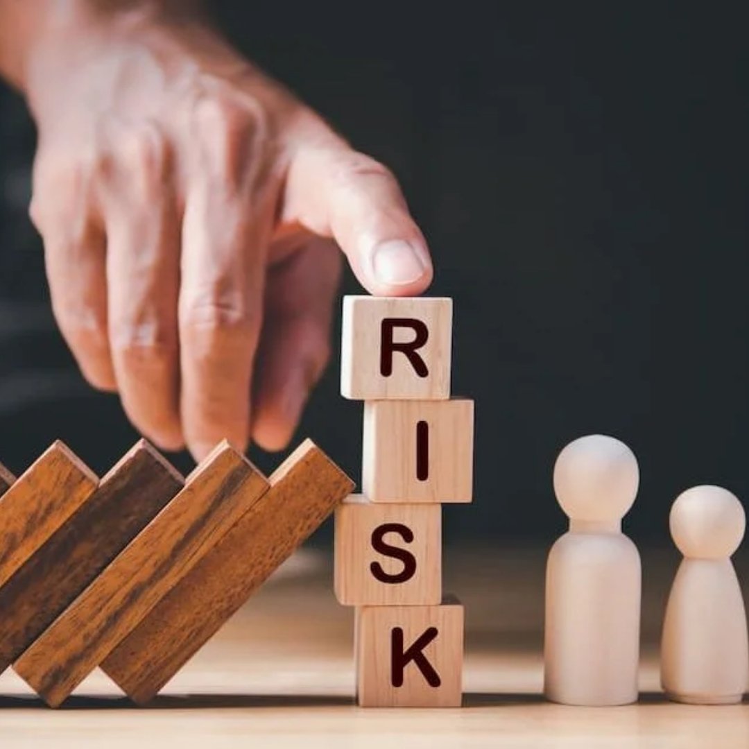 Wooden blocks spelling RISK being stabilised by hand